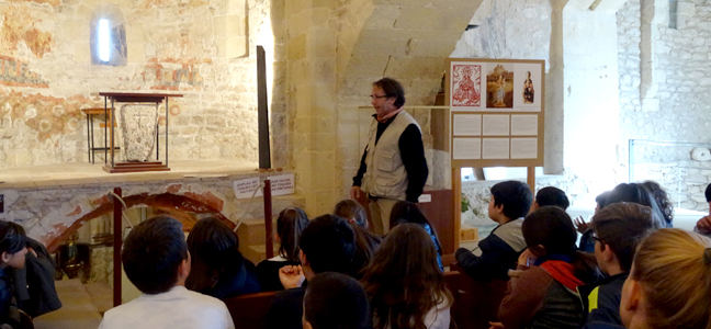 Un educador amb un grup d'infants a l'interior del Castell de Calafell