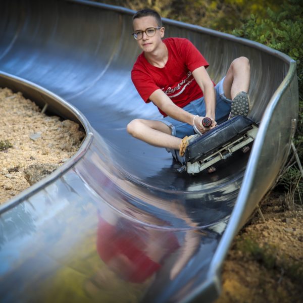 Boy wearing a red T-shirt and shorts at Calafell Slide